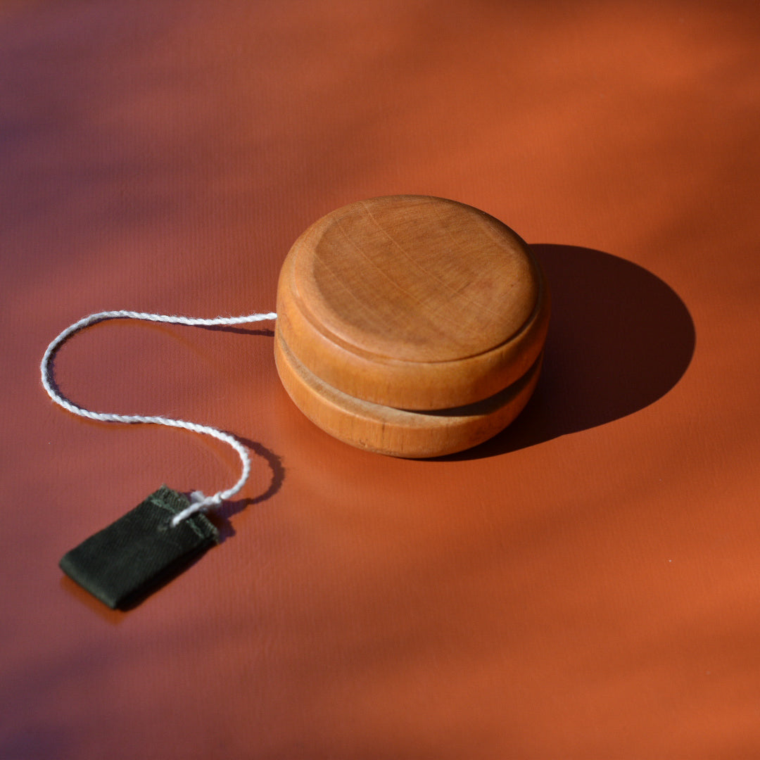 an image of a wooden yoyo on an orange background